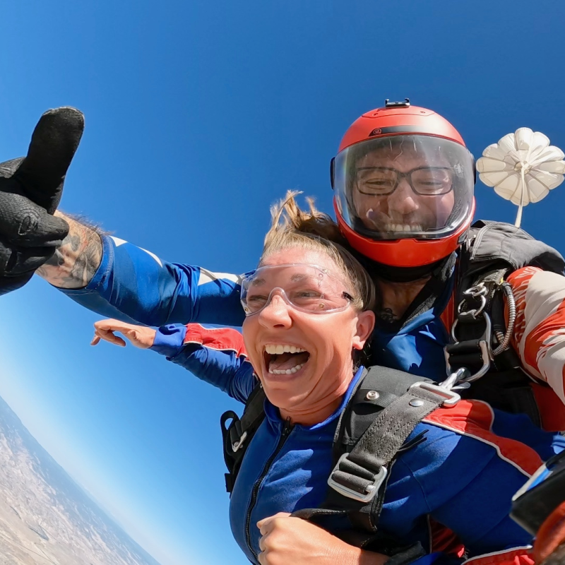 Nina tandem skydiving with a big smile on her face.